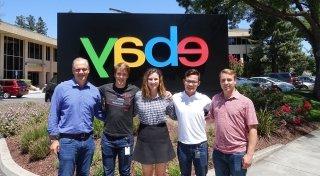 Four Saint Lawrence University students stand with an alumni mentor in front of the ebay sign.