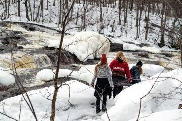 St. 劳伦斯的学生们在小溪边的雪地里散步